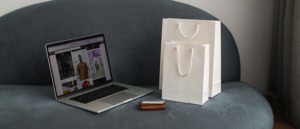 Pantalla ordenador mostrando un ecommerce y bolsas de compra