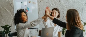 Tres mujeres empresarias celebrando su éxito