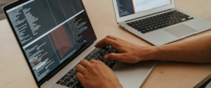 Varias pantallas de ordenador mostrando código de programación, ilustrando el desarrollo de software.