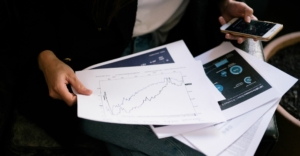 Profesional analizando gráficos y datos en una pantalla.