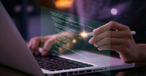 Primer plano de manos programando código fuente sobre un ordenador portátil, simbolizando la creación de software adaptado a las necesidades del negocio.